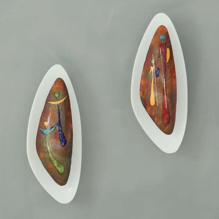 Two hand-made Italian wall lamps made out of an old plastic wall mount and an enamelled metal, multi-coloured shade. The shades show two biblical images: two angels and two of the kings.