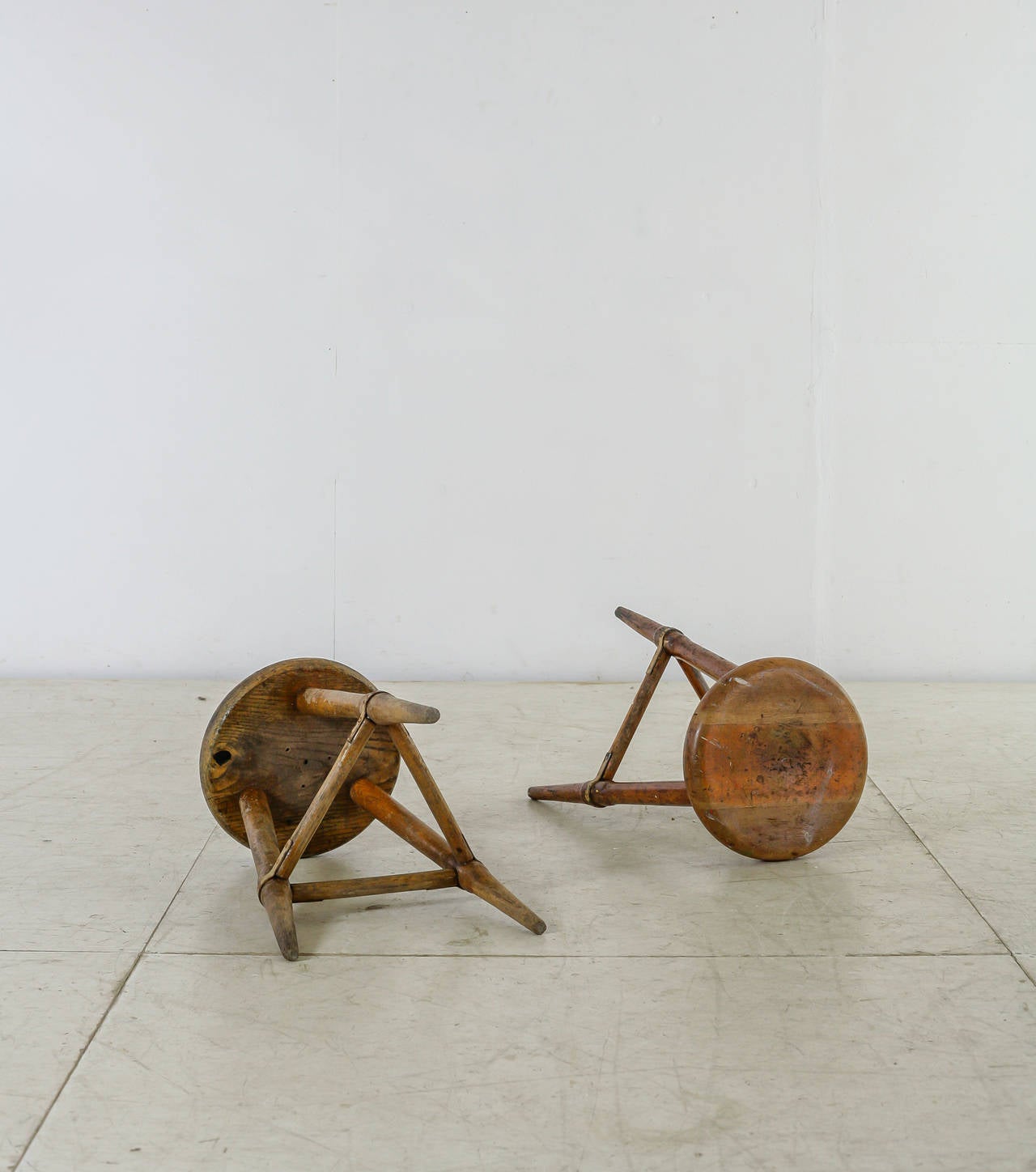 A pair of high Scandinavian wooden tripod stools. The iron in combination with the heavy patina of the wood gives these pieces a beautiful, rugged look.The three legs are held together with wooden dowels with wonderful iron connections.