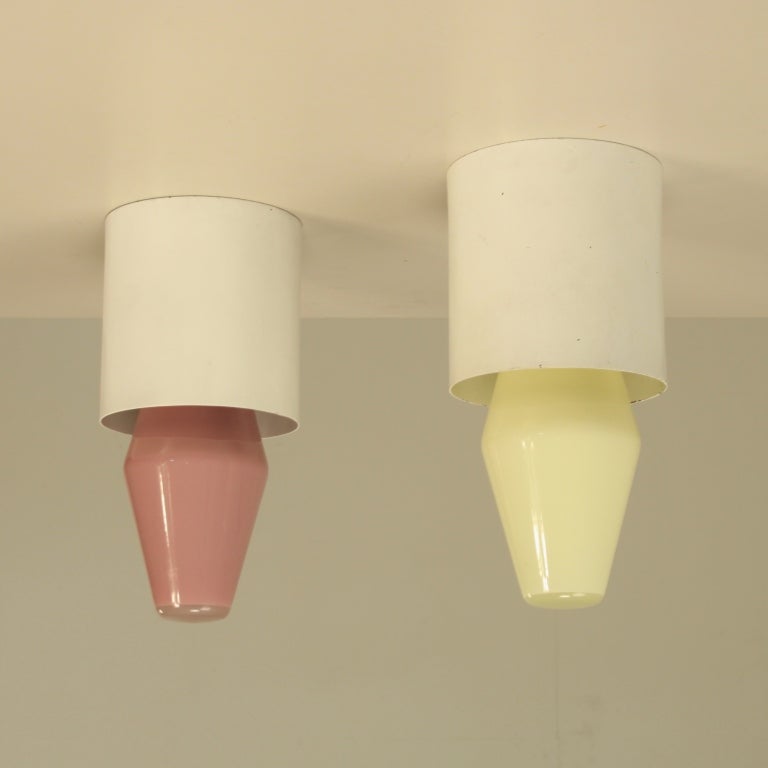 Unique pair of labeled Idman ceiling lamps in white metal, here combined with equally rare yellow and pink opaline Airam light bulbs. Both designed by Tapio Wirkkala, both old stock and with original packing. Light bulbs are available in four