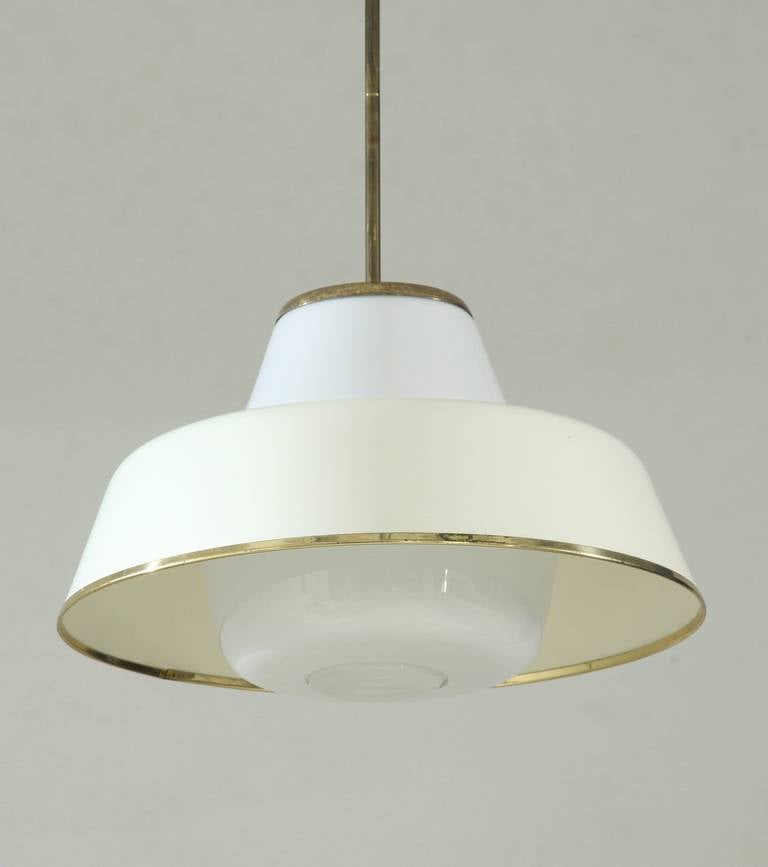 Simple and elegant pendant. White glass base with metal shade and old plastic diffuser. Brass rim around the shade and brass stem and canopy.