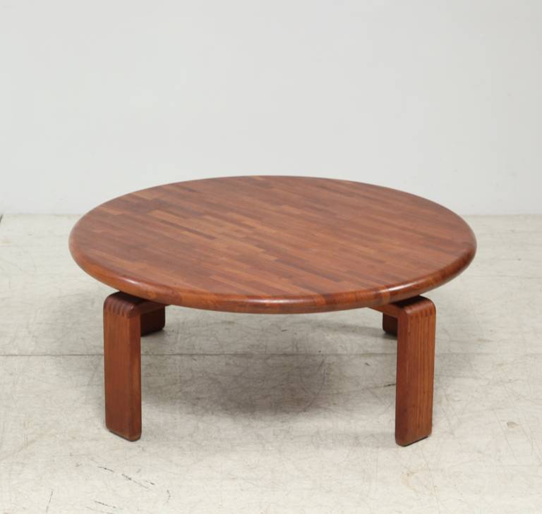 A round, wooden coffee table on four bent legs.
* This piece is offered to you by Bloomberry, Amsterdam *

The beautiful and warm effect of the different shades of the slats of wood used in the top shows the hand of a master woodworker.