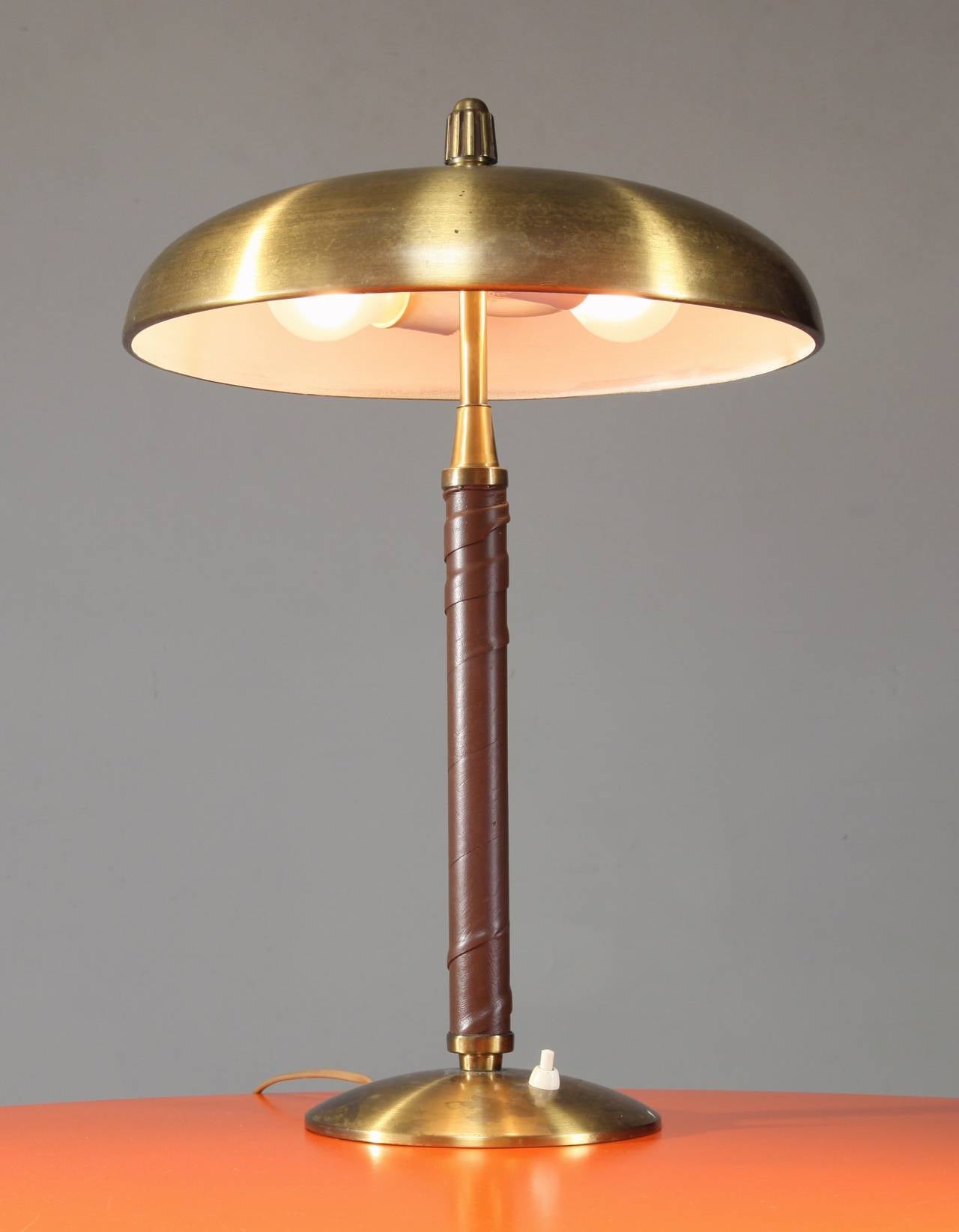 A table lamp made of brass with a leather wrapped stem, designed and made by Einar Bäckström in his own workshop in Malmö, Sweden.
The lamp has two lightbulbs and is in an excellent condition.
