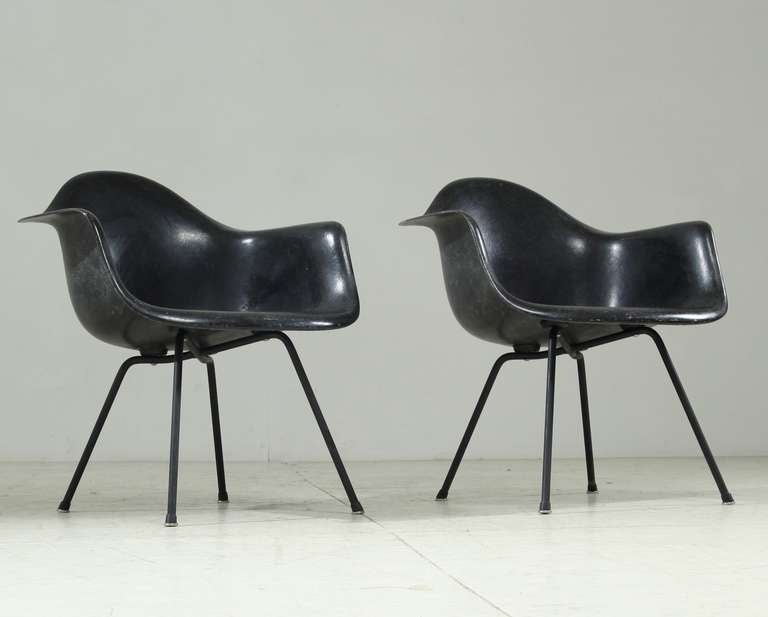 Set of iconic Eames armshells on black x bases with domes of silence glides. Both chairs and bases are in excellent condition.