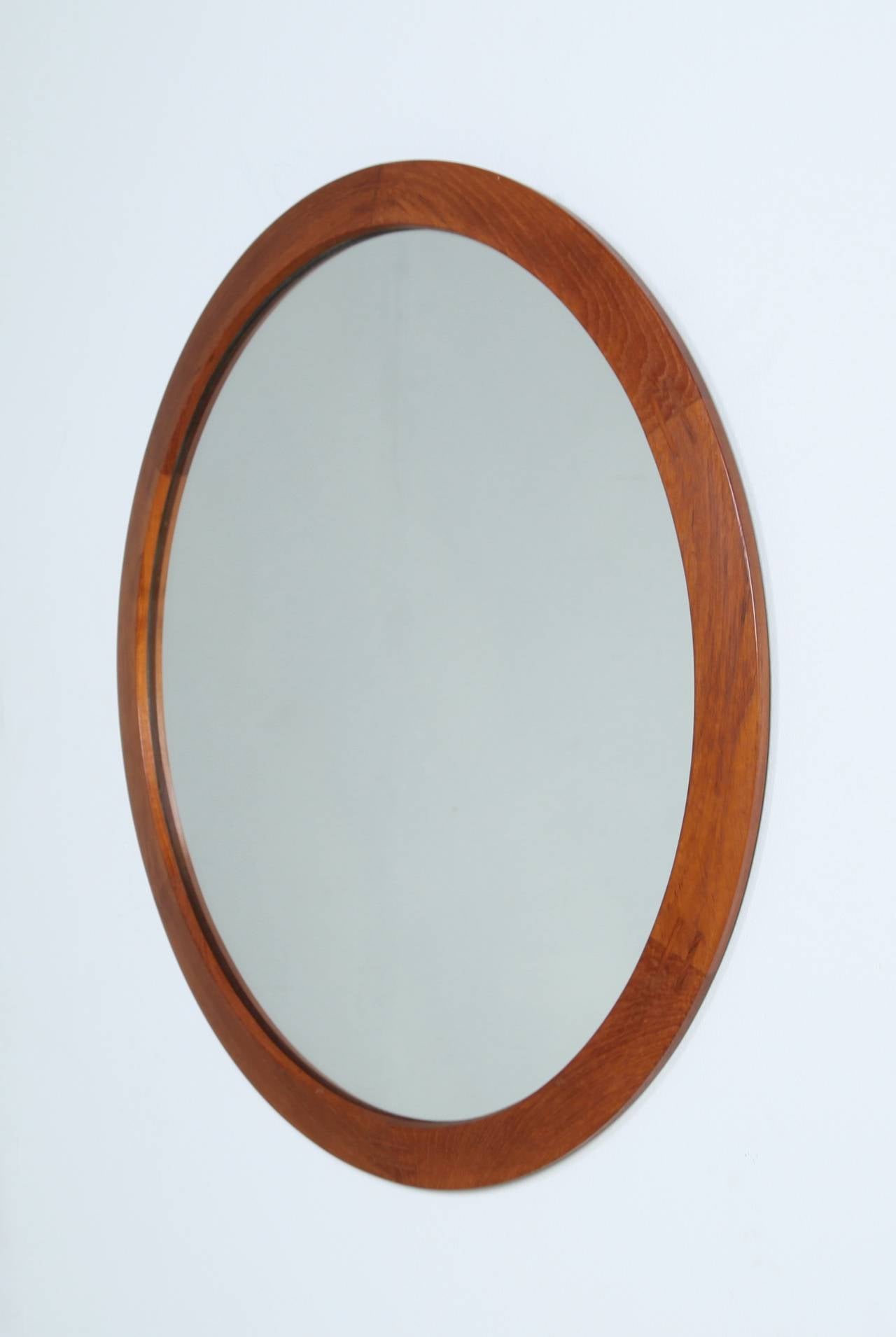 A round teak mirror by Danish designer Aksel Kjersgaard for Odder furniture. In perfect condition and marked by Kjersgaard.