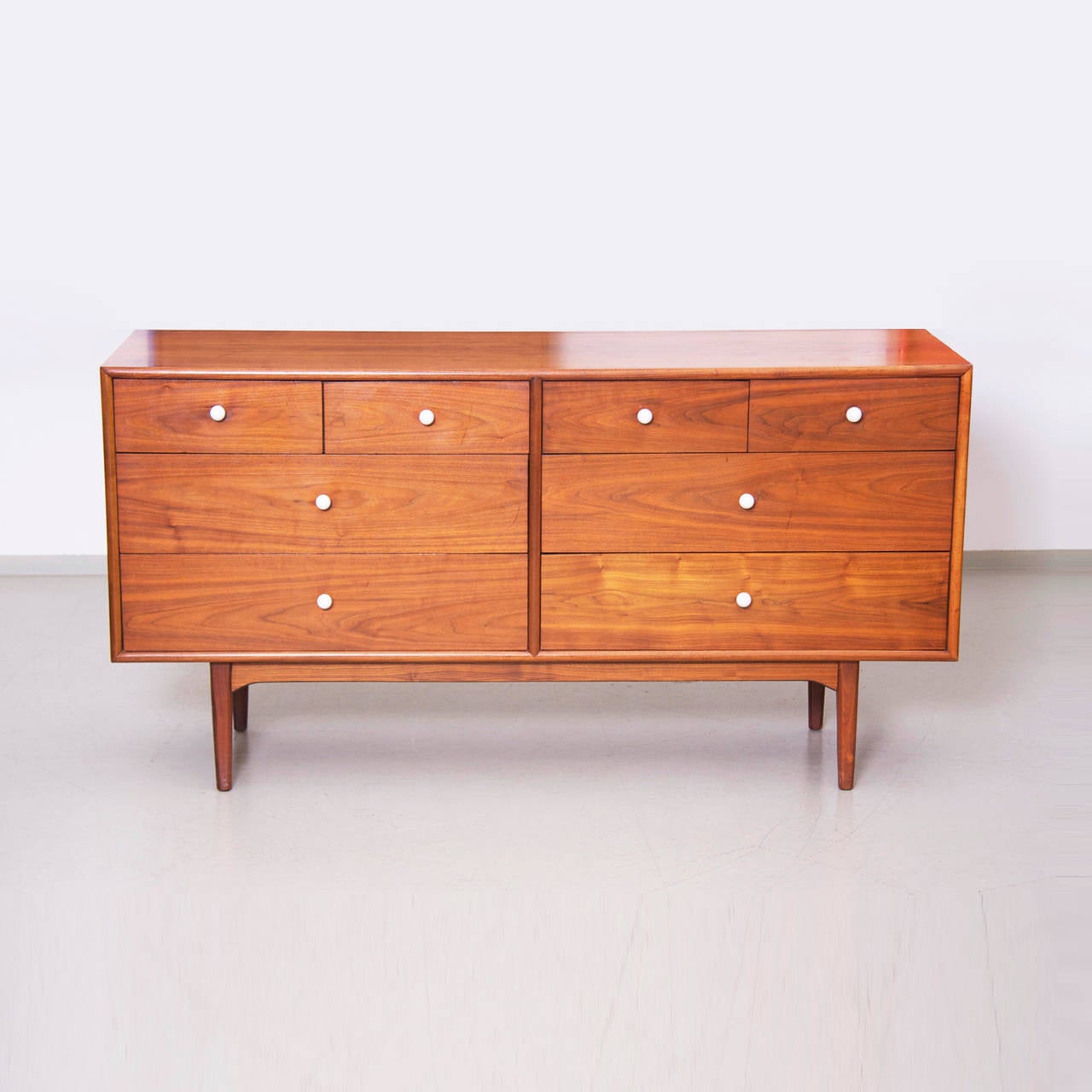 Fabulous Kipp Steward Drexel Declaration walnut credenza. This piece has an amazing vintage patina, the original finish glows the beautiful graining. The hardware is the Classic white porcelain balls with the brass details. All dovetail drawer