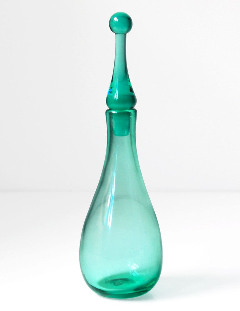 Small teardrop shaped decanter with arrowhead stopper with ball on top, designed by Wayne Husted in 1963, made for 1 year only.

Design #6311S in Sea Green, pictured in the 1963 catalog.

___

All our glass is vintage mid-20thC hand blown art