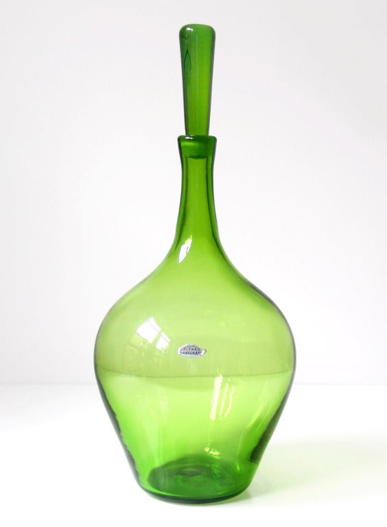 Very large decanter with broad shoulders and tapered cylinder stopper, designed by Joel Philip Myers in 1966. Design #6631 in Olive Green, pictured in the 1966 catalog.

___

All our glass is vintage mid-20thC hand blown art glass. Items are
