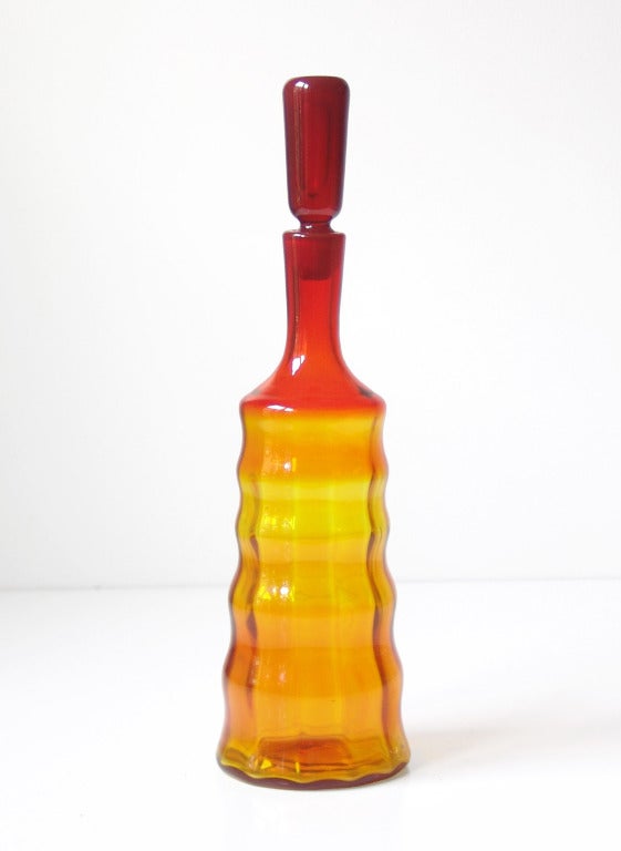 _____<br />
(Items shown in groupings are also available individually, please email to inquire.)<br />
LEFT: Cylindrical optic rib decanter with accordion-like body, designed by Joel Philip Myers in 1965. Design #658S in Tangerine, pictured in the