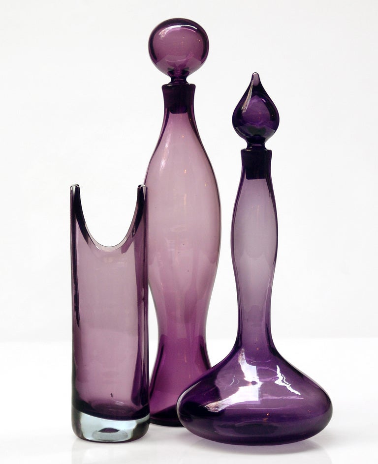 ______

(Items also available individually, please email to inquire.)

LEFT: cylindrical vase with thick crystal base and shaped & ground top , designed by Wayne Husted in 1959, made for 1 year only. Design #5942S in Lilac, pictured in the 1959