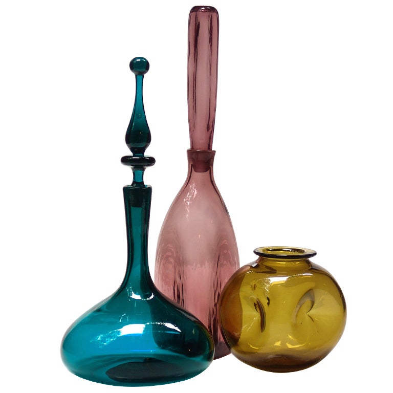 A trio of vintage Blenko glass decanters in muted colors