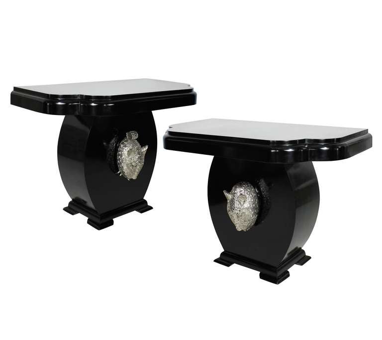 A stunning pair of English black lacquered oak art deco console tables, with beautifully shaped tops and bases. With life size silver leopard heads.