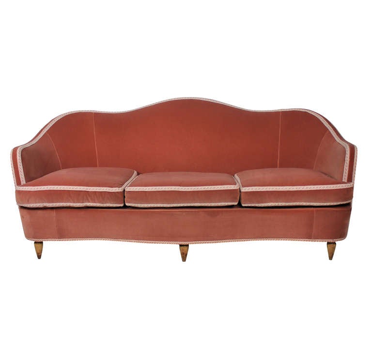 A large Italian settee of elegant curvy design in the style of Ulrich. Beautifully upholstered in rose velvet with silk braid.