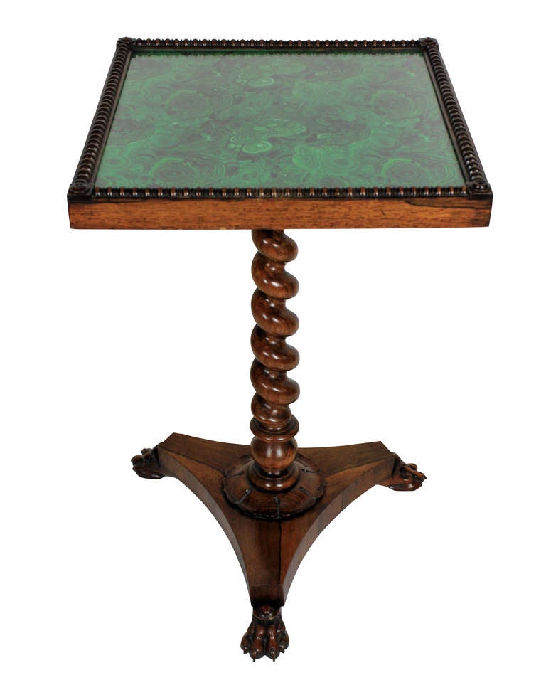 An English William IV rosewood pedestal table, with a barley twist central baluster and a lion paw triform base. The glass top containing faux malachite underneath.