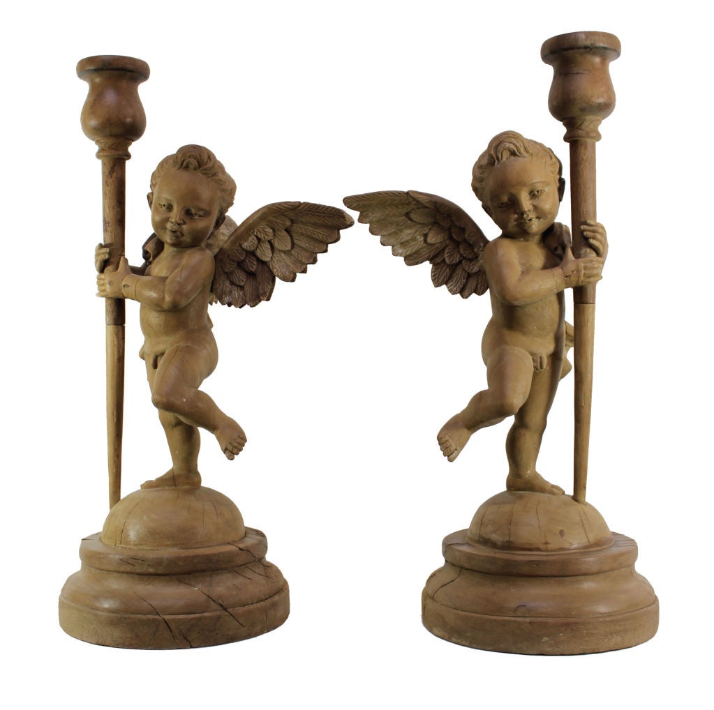 A Pair Of Italian Carved Limewood Putti Holding Torcheres