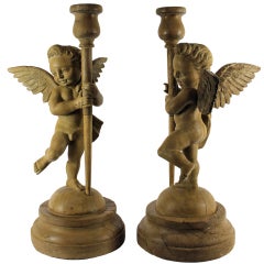 A Pair Of Italian Carved Limewood Putti Holding Torcheres