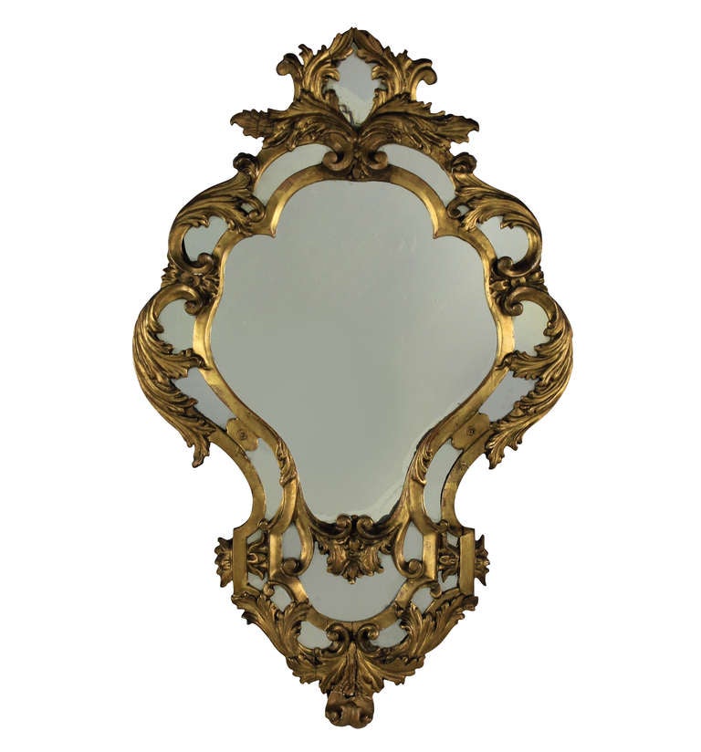 A pair of French carved and water gilded girandole mirrors of cartouche shape.