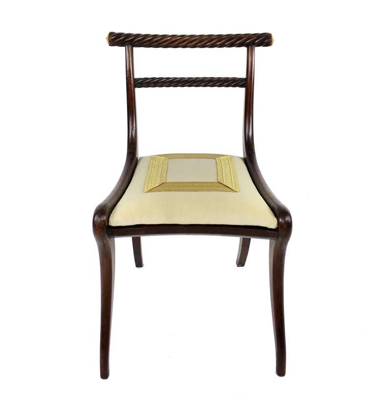 A pair of fine Irish mahogany 'Trafalgar' chairs. With unusual rope twist back rails and Klismos style legs. With gilt bronze acanthus paterae and each chair stamped to the underside. Upholstered in ivory velvet with a military gold braid