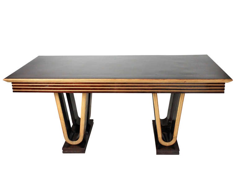 An Italian dining table of unusual design in rosewood and maple, with a beautifully curved base of geometric design.