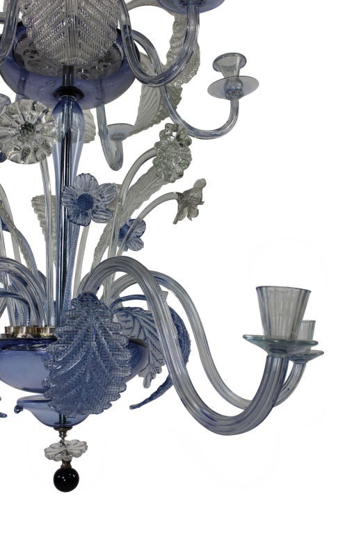 A large Venetian chandelier in pale blue and clear glass. Comprised of twelve arms in two tiers with handblown stem, arms and foliage. The metal fittings are silver plated throughout.