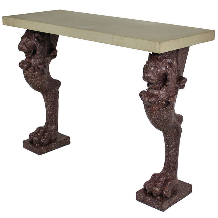 An English console table in the Classical style, comprising two large faux porphyry lion paw legs and a York stone top