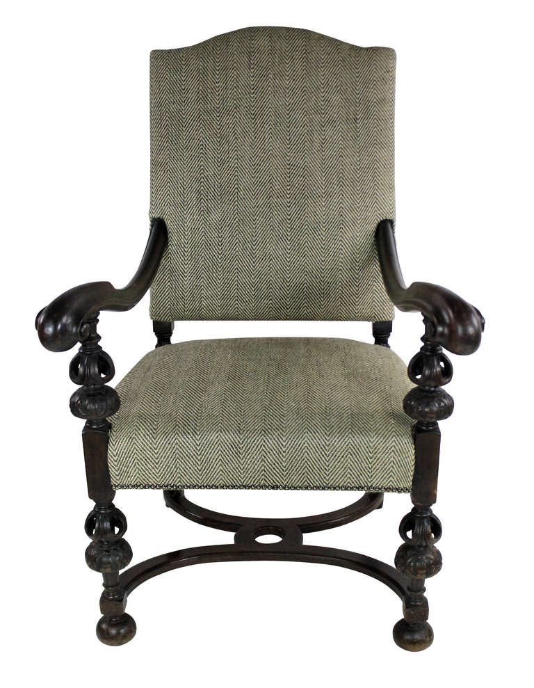 A French walnut armchair in the 17th Century Baronial style. Beautifully carved and newly upholstered.