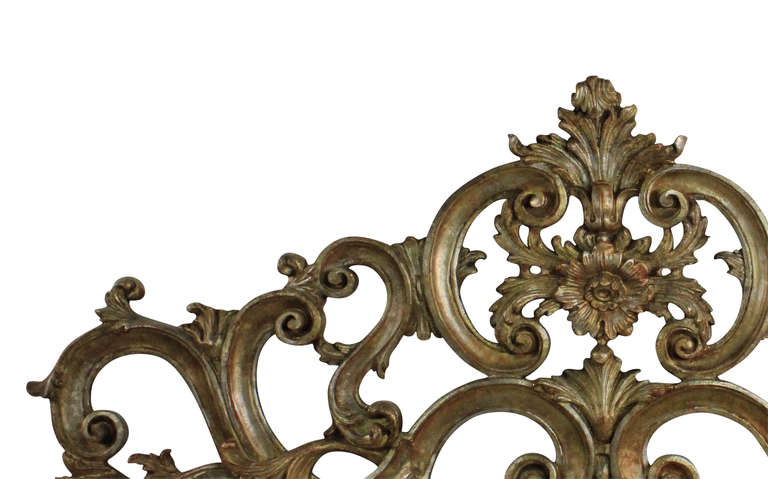 An Italian king size carved wood and silver leaf rococo headboard.