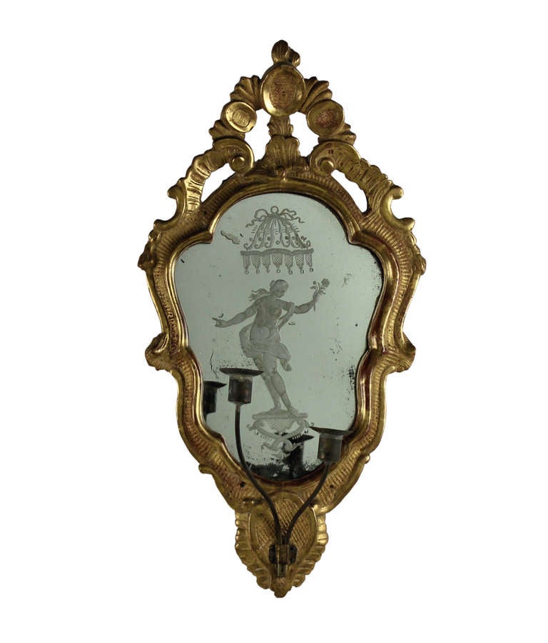 A pair of Italian girandole in carved and water gilded cartouche shaped frames containing etched mercury glass mirror plates depicting Roman Gods. With metal candle sconces.

Please note this item is subject to VAT