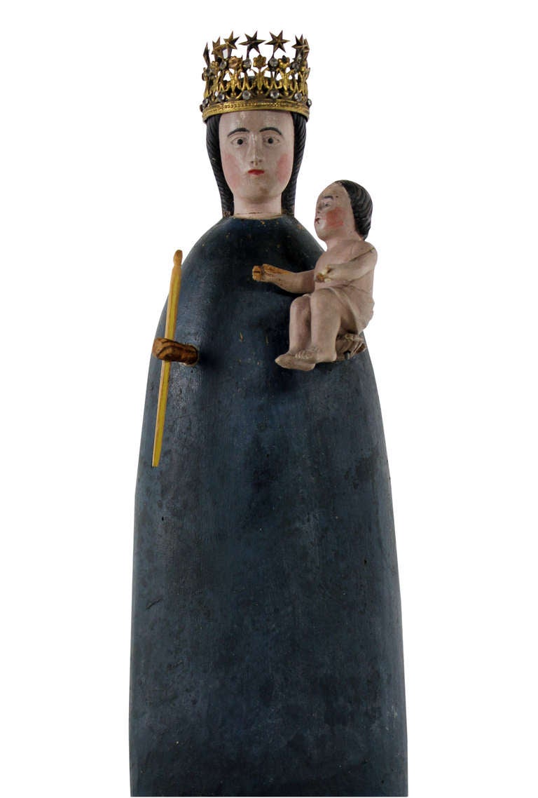 A Spanish carved and polychrome painted figure of the Virgin & Child within a glass dome. The Virgin wears a gilt metal crown with semi precious stones.
