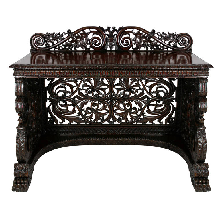 A William IV Anglo (Irish) Indian profusely carved serving table of exception quality, of three sided design carved out of solid rosewood in a foliate manner with large lion paw feet and a stylised crown to the central frieze. A rare and beautiful