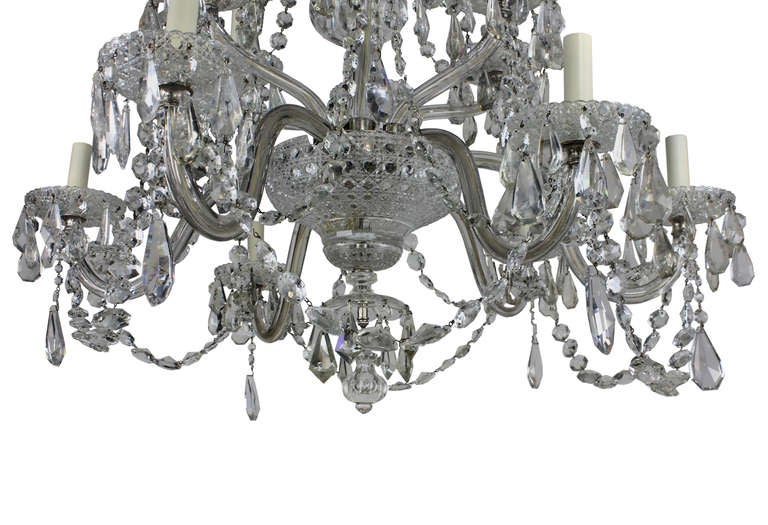 A large English cut-glass chandelier of good quality. Of six down swept and six up swept arms, decorated heavily with swags and pendant drops.