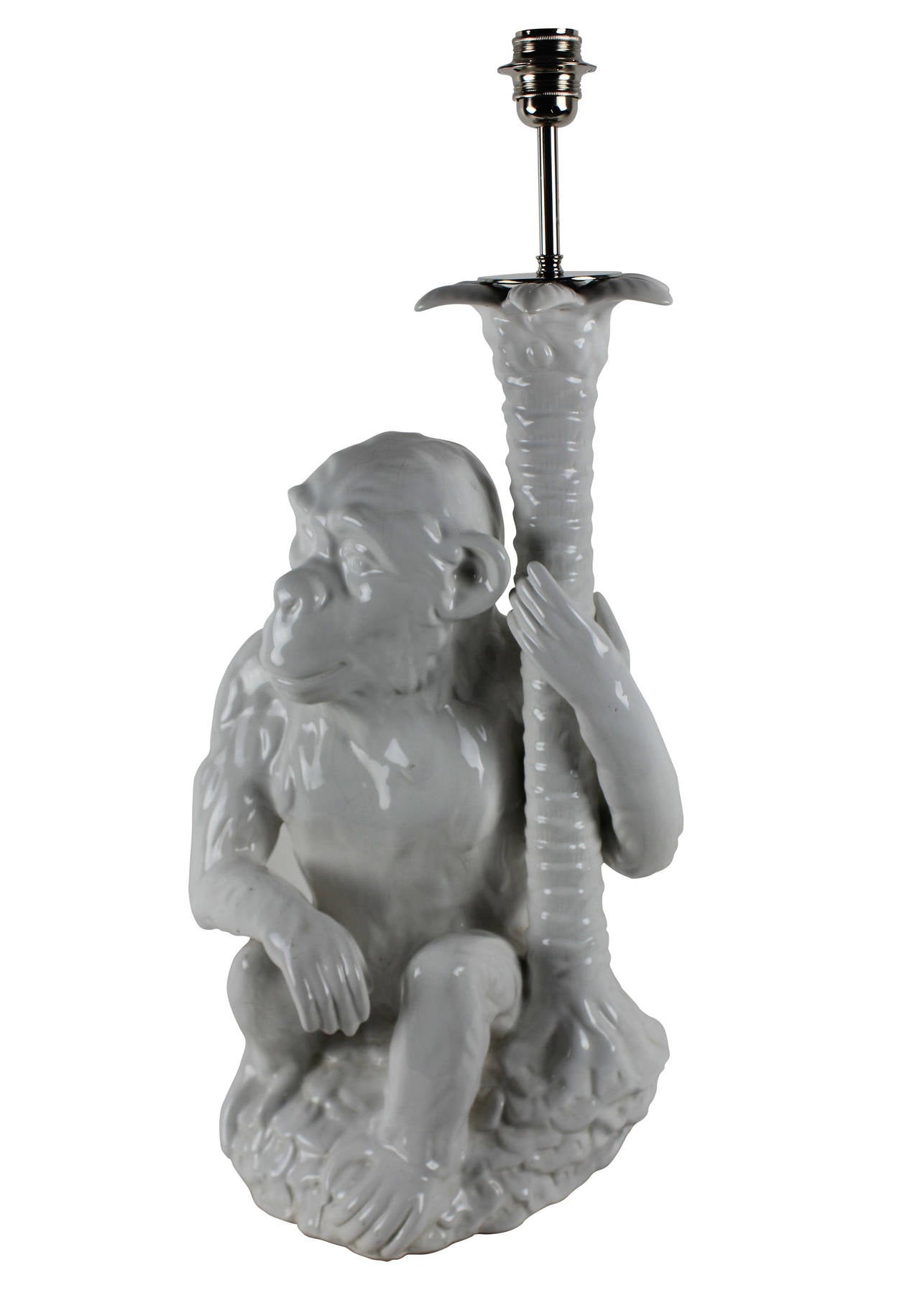 A Portuguese white glazed ceramic lamp depicting a monkey and palm tree.