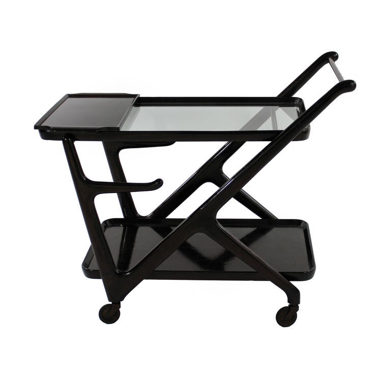 An Italian bar cart in dark rosewood, with glass shelves and portable tray. By Cassina.
Literature: Domus