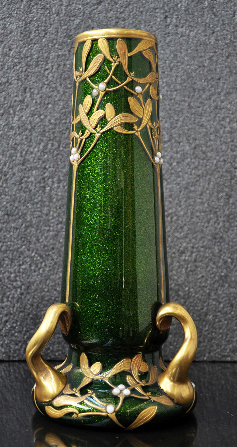 This exceptional and rare model of glass vase is marked by the Montjoye Saint-Denis manufacture and was made in the early 20th century. In a green aventurine color background, a mistletoe decor is applied in a gilding treatement to enhance the