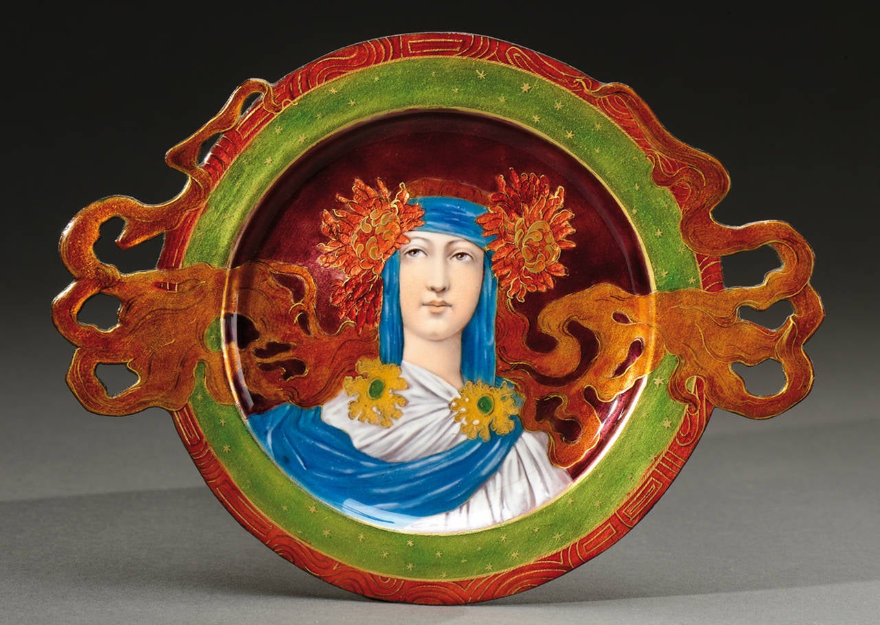 This polychrome enamelled copper dish representing a young woman was realized by Théophile Soyer (1853-1940), circa 1900. 
The longue red hair forms small openwork handles. 
Théophile Soyer is the main representative of a great enamelers dynasty