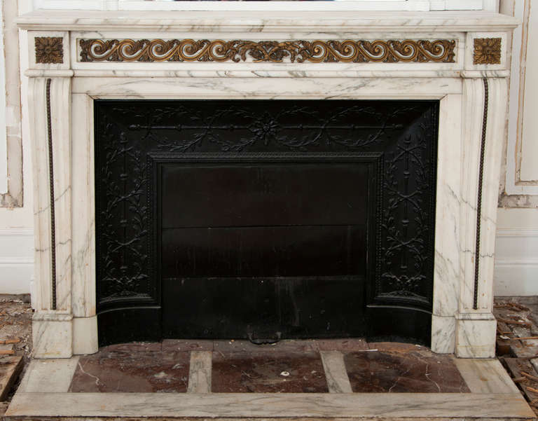 This antique Louis XVI style fireplace was made out of Arabescato marble with gilde bronze sculptures during the 19th century. The frieze is decorated along its length with a frieze of stylized waves with leaves made ​​of gilded bronze. Winding