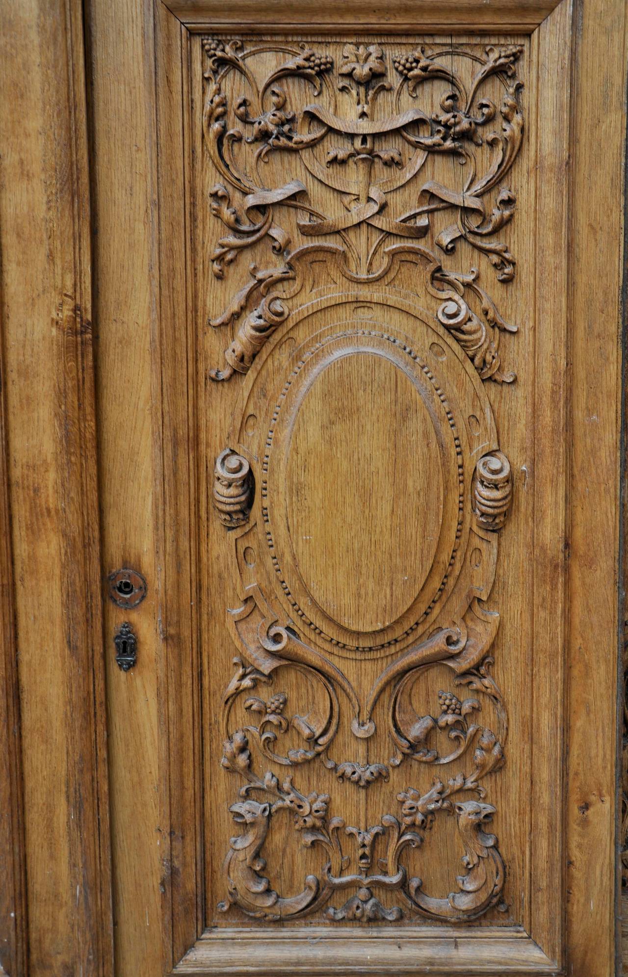 This pair of double doors was made out of carved oak wood during the 19th century. This decor of grotesques, foliages and chimeras is highly interesting. 
The handles and hinges are provided.
The back decor is made out of stucco.