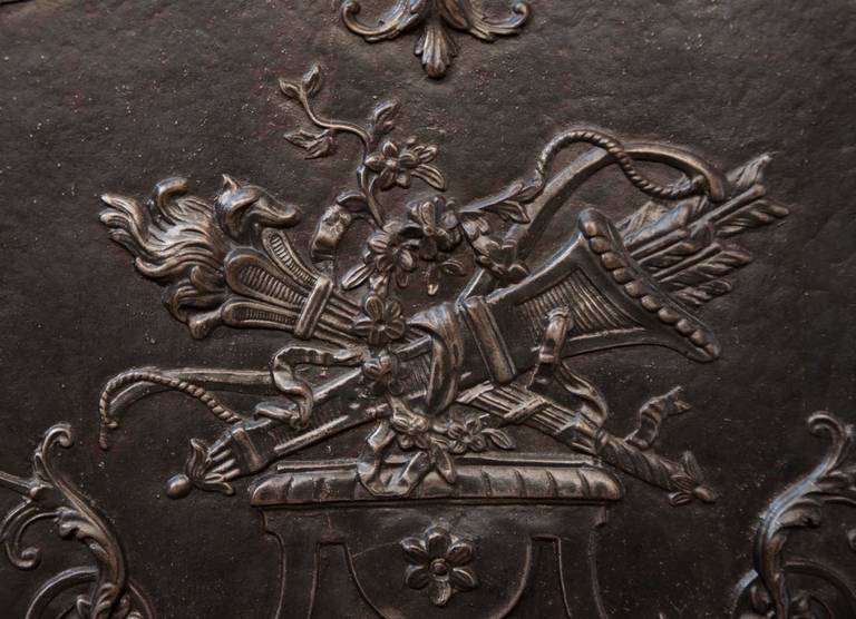 19th century period, ornated with a torch and a quiver placed on a pedestal with vegetals and foliages. The fireback is in very good condition. The quality of the decor is really fine.