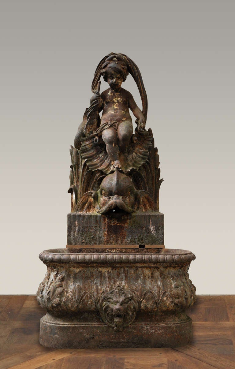 This monumental garden fountain was realized in cast iron in the second half of the 19th century by the Ducel Foundry. A naked putti is seated on a dolphin above reeds. 

The Ducel Foundry was founded in 1810. Part of the precursors for the