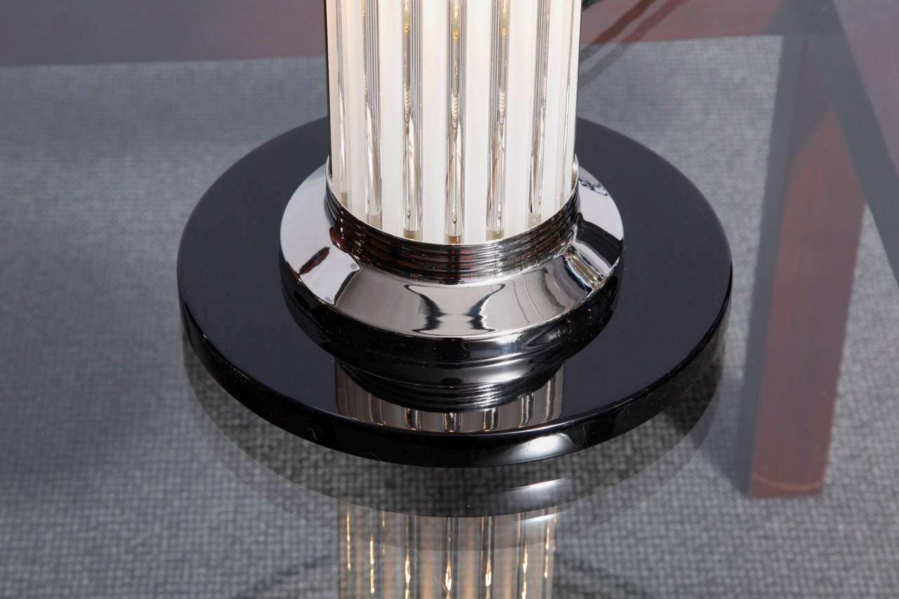 A nicely designed pair of Art Deco lamps designed by Atelier Petitot, France.
 Black lacquered wooden base with nickel plated metal elements, glass tubes running from the base to the black colored shade .Two electric bulbs were placed in the body