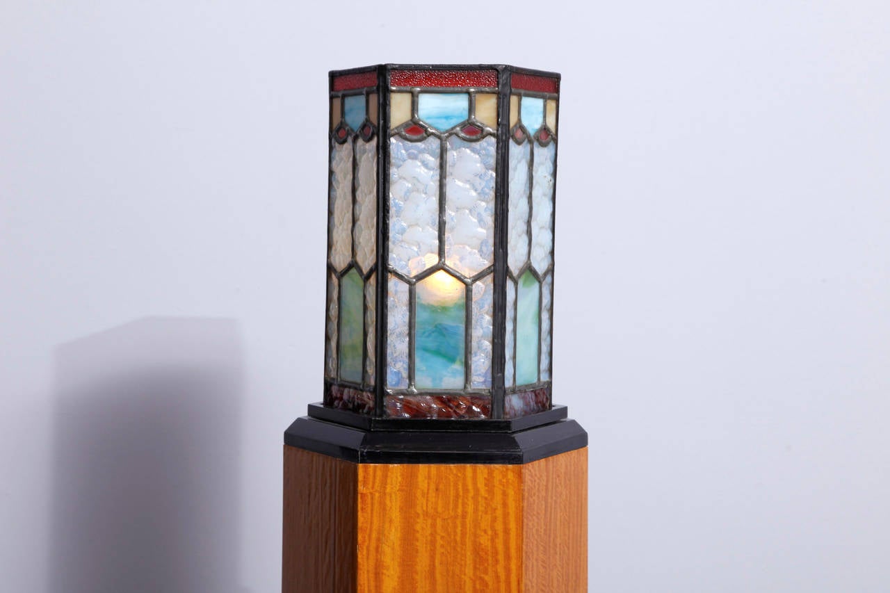 A beautiful Art Deco lamp in colored glass and metal frame on a lemonwood veneered pedestal. The pedestal is finished with handmade French polish.
Simply exceptional.