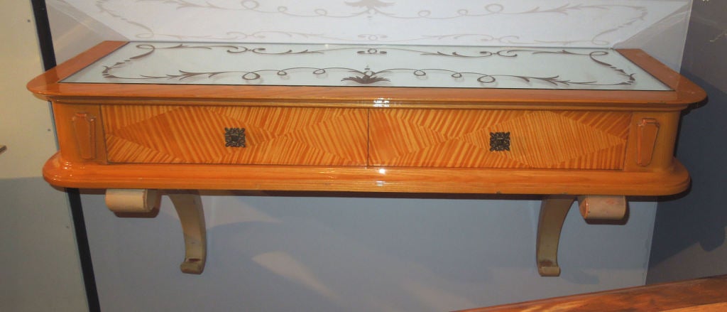 Art-deco console table in maple.The top is covered by an acid egded mirror.Two small drawers in the front with brass handels.The  console is fixed on the wall .