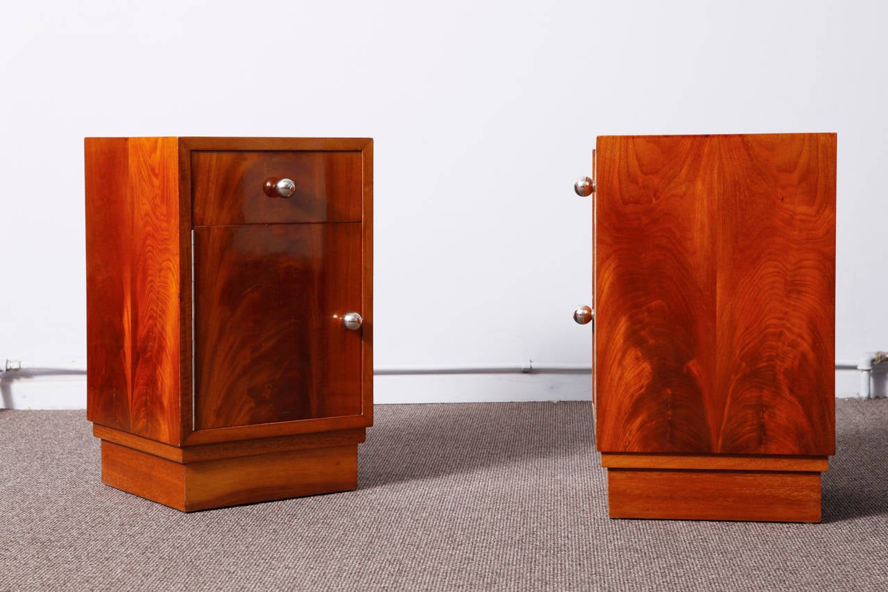 A cubist, very elegant pair of mahogany veneered Art Deco nightstands.
The mahogany veneer was repolished with a lustrous handmade French polish. Handles are in nickel-plated bronze. One-drawer and one door on each item. French origin.