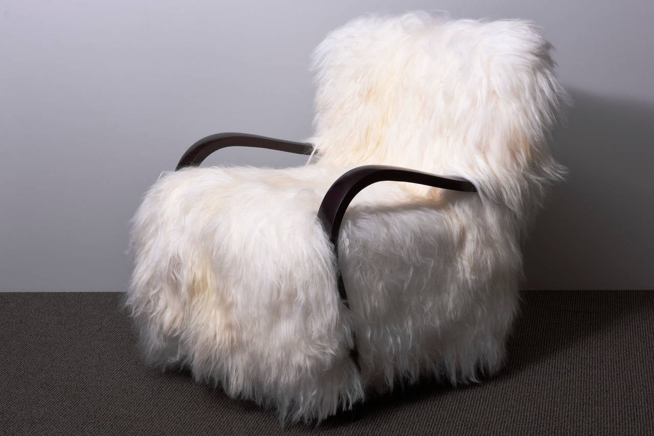 A very exceptional pair of Art -Deco armchairs, reupholstered with a long haired Iceland sheep fur. The chairs were completely restored, the wooden parts are finished with a palissander colored lacquer and they were refurbished and recovered with a