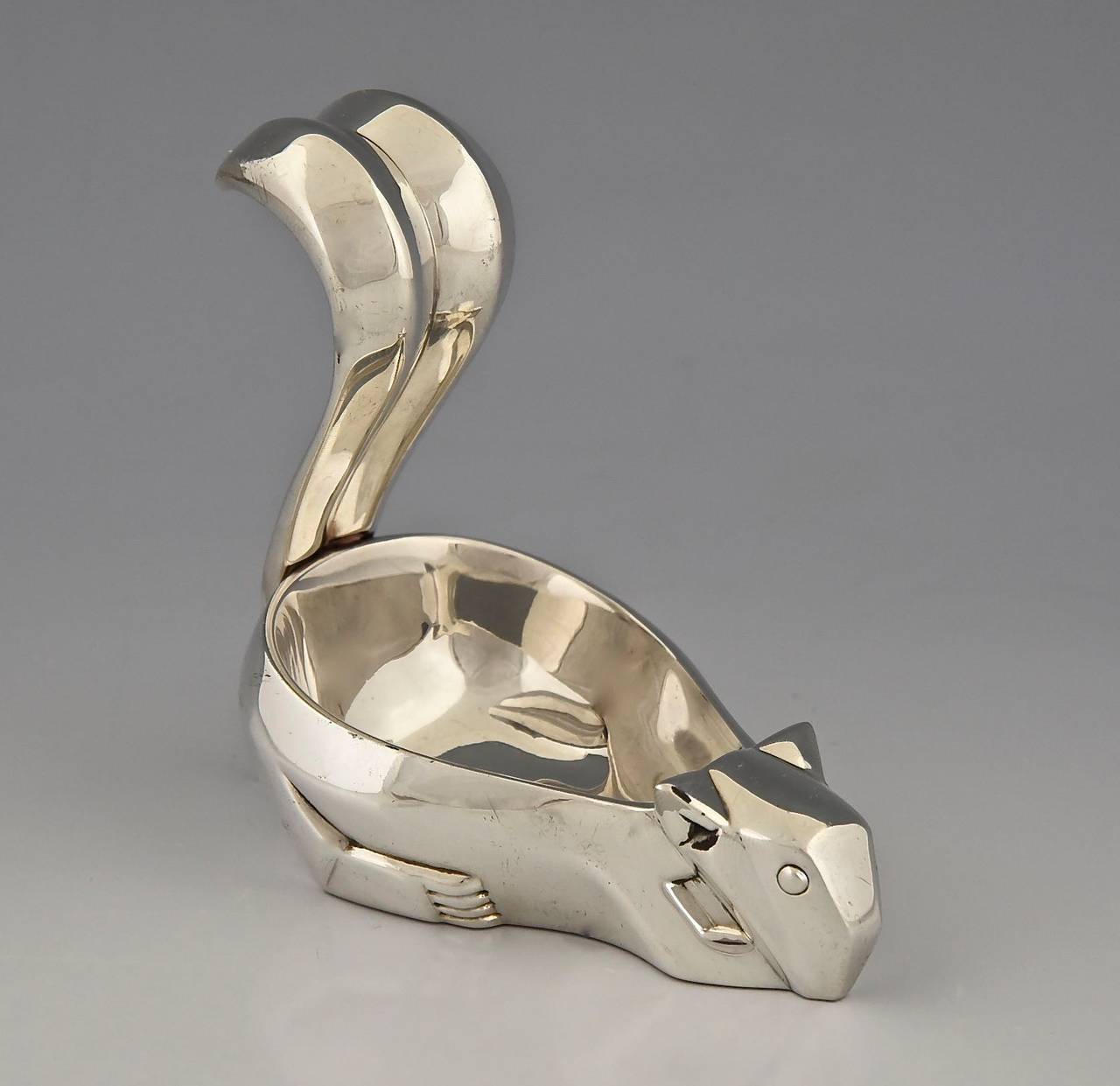 Art Deco nut dish modeled as a squirrel.
 Designed by Antoinette de Ribes (1892-1972) in 1931.  
Executed by Christofle in the 1980s. 

Marks:  Christofle marks.
Style:  Art Deco. 
Date:  Design 1931. 

Material:  Silver plated metal.