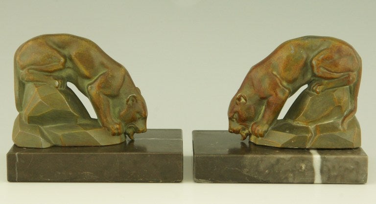 A pair of patinated metal bookends with panthers on a rock.
Bases are in marble.
The bookends are signed by Louis Albert Carvin, a French artist.

Literature:
 “Animals in bronze” by Christopher Payne. Antique collectors club. 