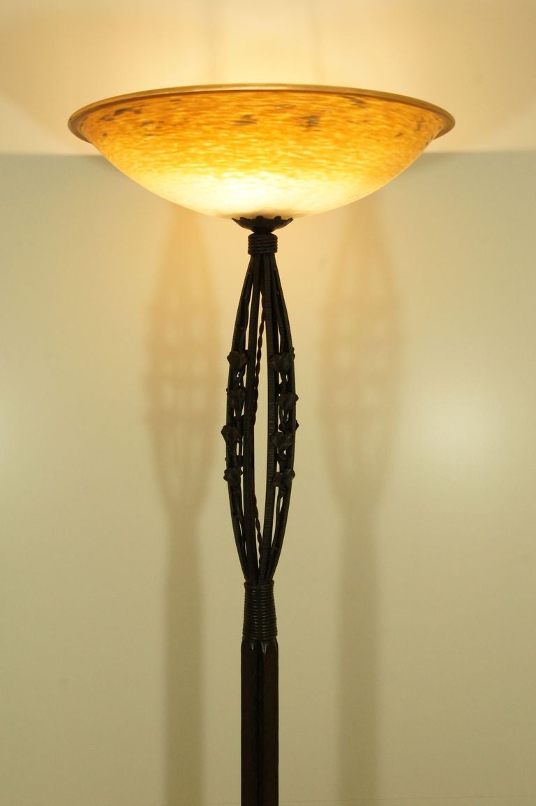 A Schneider and Henri Fournet floor lamp.

Signatures:
Schneider on the glass shade for Charles Schneider. 
Signature for the period 1918-1922.
H F on the wrought iron base for Henri Fournet “Le Fer Forgé”, Lyon 

Cloudy orange, yellow and