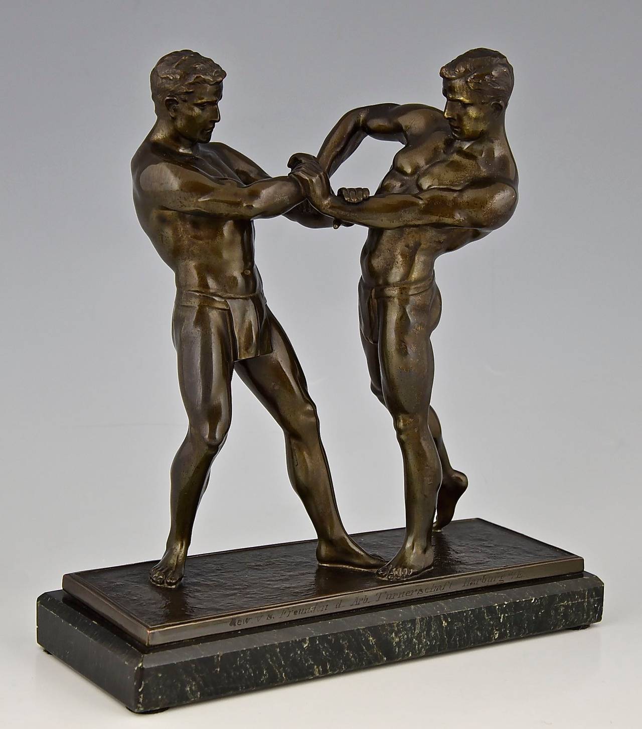Sculpture of two wrestlers. 
Date:  1910.		
Material: Patinated metal.  Marble base. 	
Origin:  Germany.			
Size:			 
 H. 9.3 inch x L. 8.5 inch x W. 3.3 inch. 
H. 23.5 cm. x L. 21.5 cm. x W. 8.5 cm. 
Condition:  Good original condition.