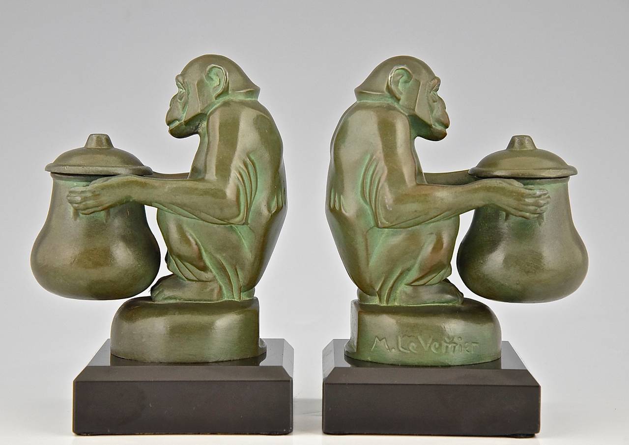 A pair of Art Deco monkey bookends.  Each monkeys is holding an inkwell in the shape of a jar. 
Signed:  Max Le Verrier. 
Style:  Art Deco. 
Date:  1935.
Material: Green patinated metal. Marble base. 
Origin:  France. 
Size of one:
H 5.9 inch
