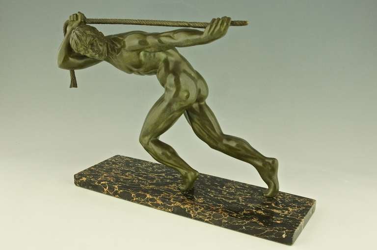 Bronze sculpture of a athletic man pulling a rope. 
By Maurice Guiraud Rivière,
Signature:  Guiraud Rivière
Style:  Art Deco. 
Date:  1930.
Material:  Bronze, green patina.  Portor marble base.
Origin:  France. 		
Size:			 
H 15 inch. x L.