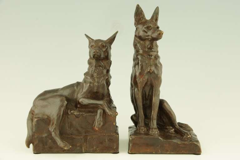 Bronze bookends of two german shepherd dogs. One alert seated dog with another lying by its side. 
By Maximilien Louis Fiot, France 1886-1953 .
Susse frères foundry. 

“Les bronzes de XIXe siècle” by Pierre Kjellberg, Les éditions des